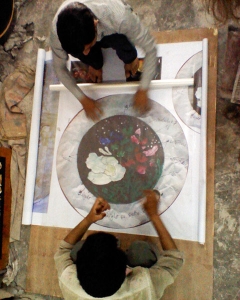 Des ouvriers en cours de travail sur un plateau de marqueterie de pierres dures avec un motif original déssiné par Samarkande circulaire         