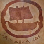 logo de Samarkande en marqueterie de pierres dures: dans les tons du sable du desert, les pierres Camel et Jaisalmer évoquent le voyage en Orient. Réalisé par notre atelier