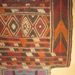 Ancien tapis de selle, en laine aux tons chauds. Provenant du Moyen Orient.